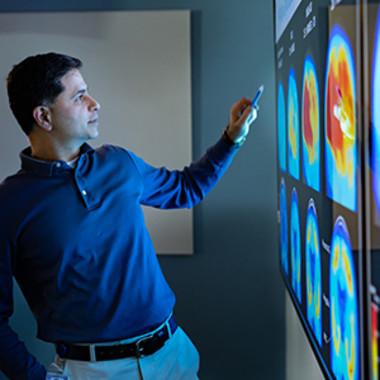 A specialist shows medical analyses on a lighted board.